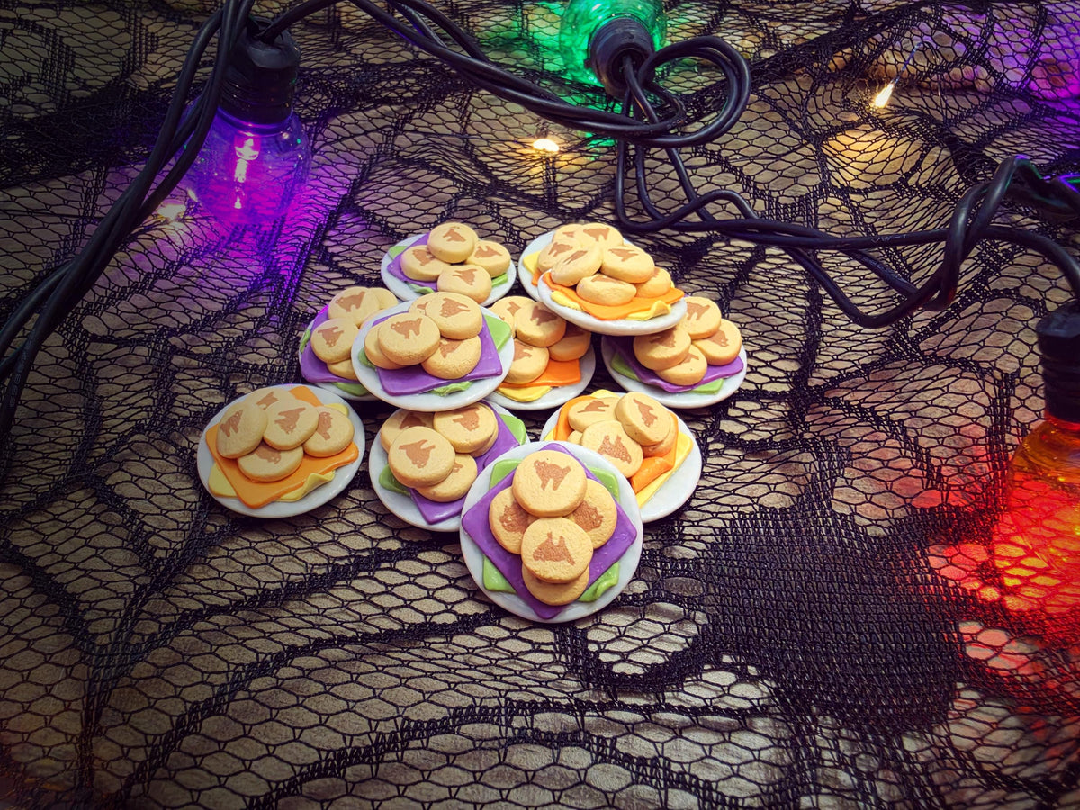 Miniature Halloween cookie plates styled on spiderweb lace with glowing string lights