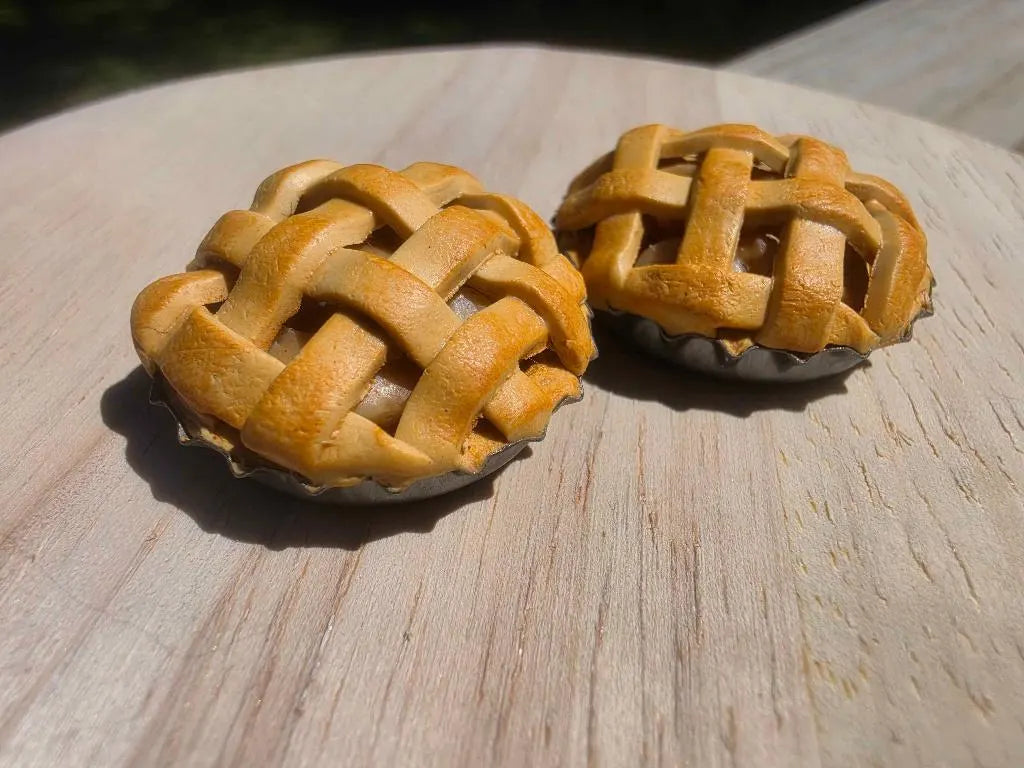 Two mini lattice apple pie magnets with woven golden crusts, handmade from polymer clay