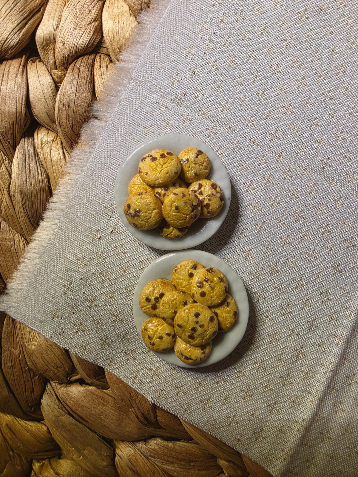 Handmade miniature chocolate chip cookie plates on a woven mat, polymer clay dollhouse miniature