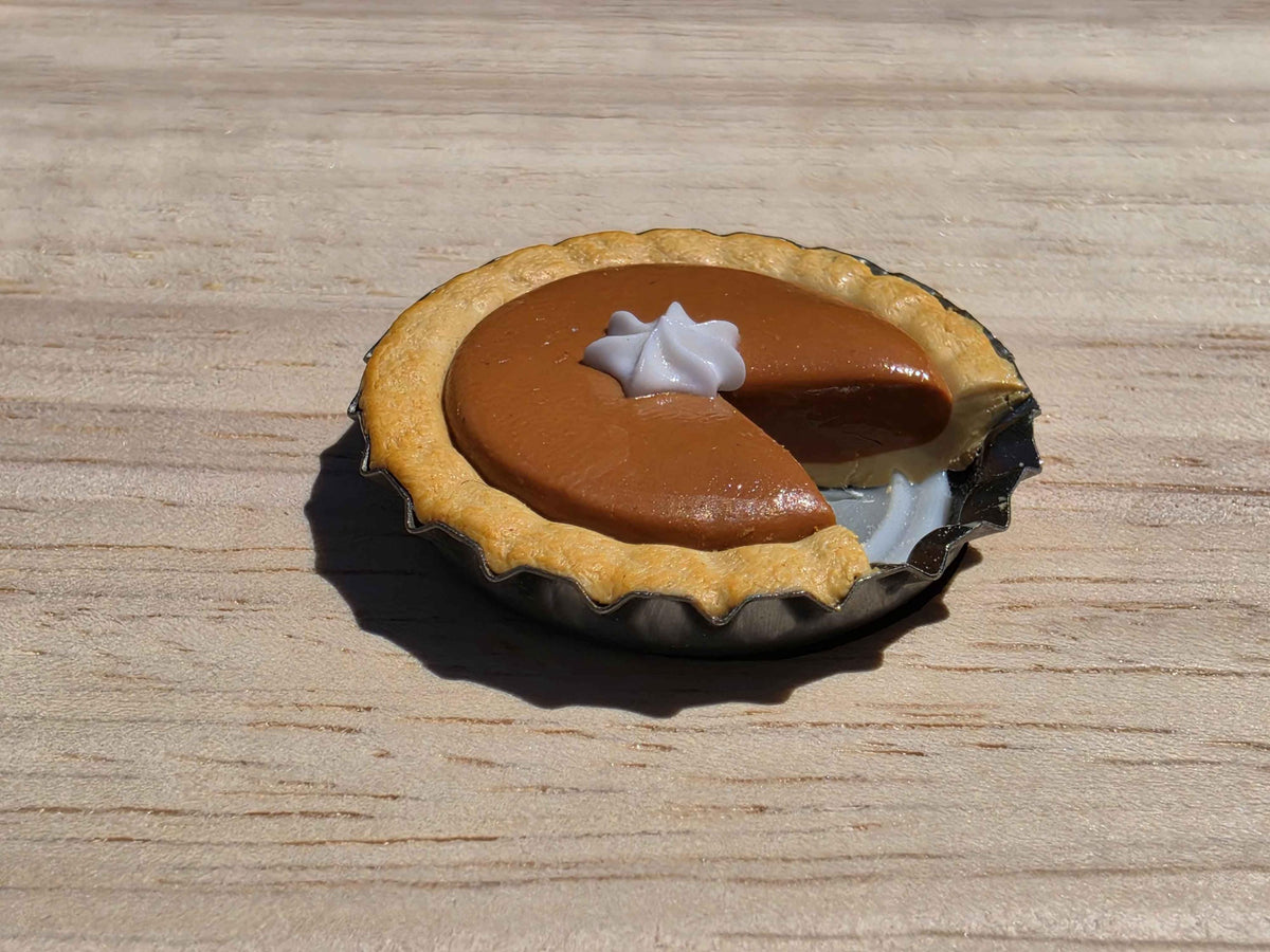 Mini pumpkin pie magnet with whipped cream dollop and a slice cut out, handmade from polymer clay