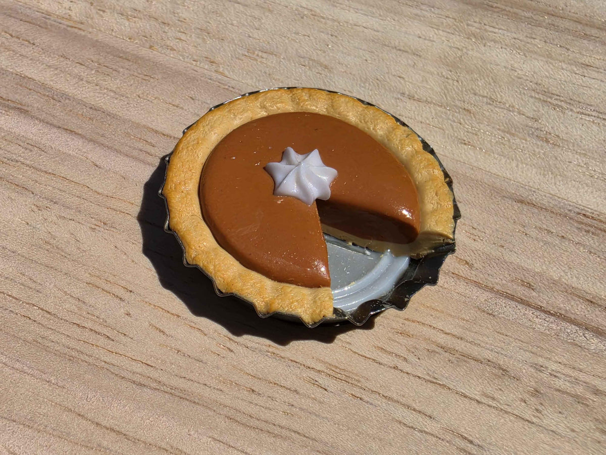 Close-up of a mini pumpkin pie refrigerator magnet with a glossy glazed filling